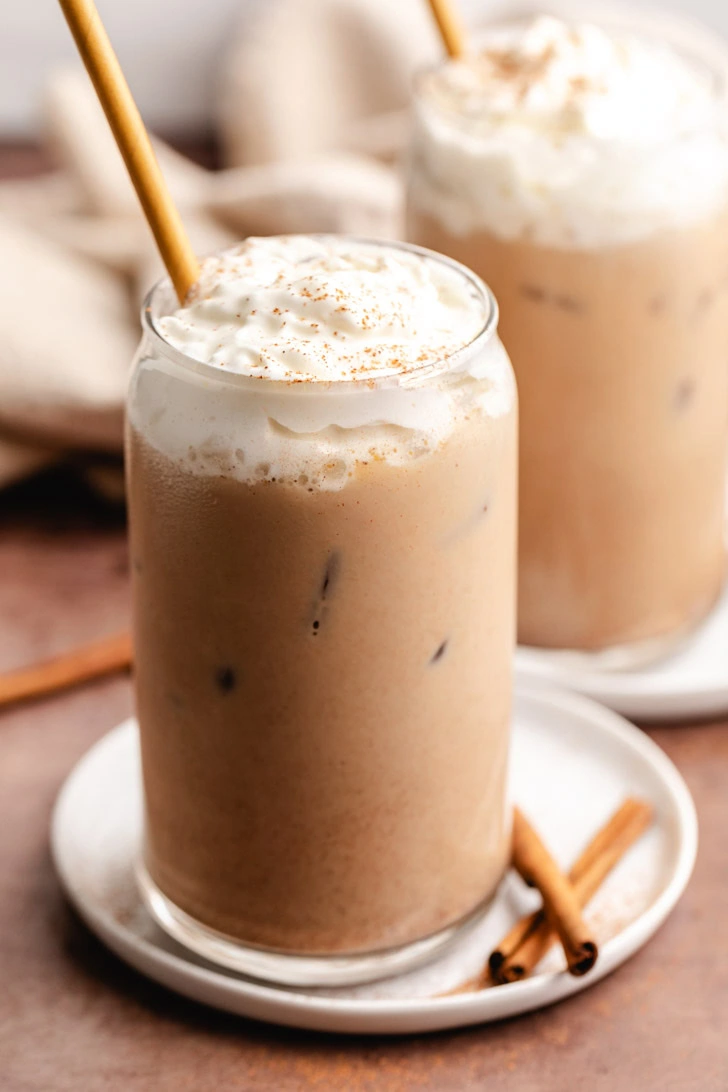 Straw in a glass of pumpkin spiced latte.