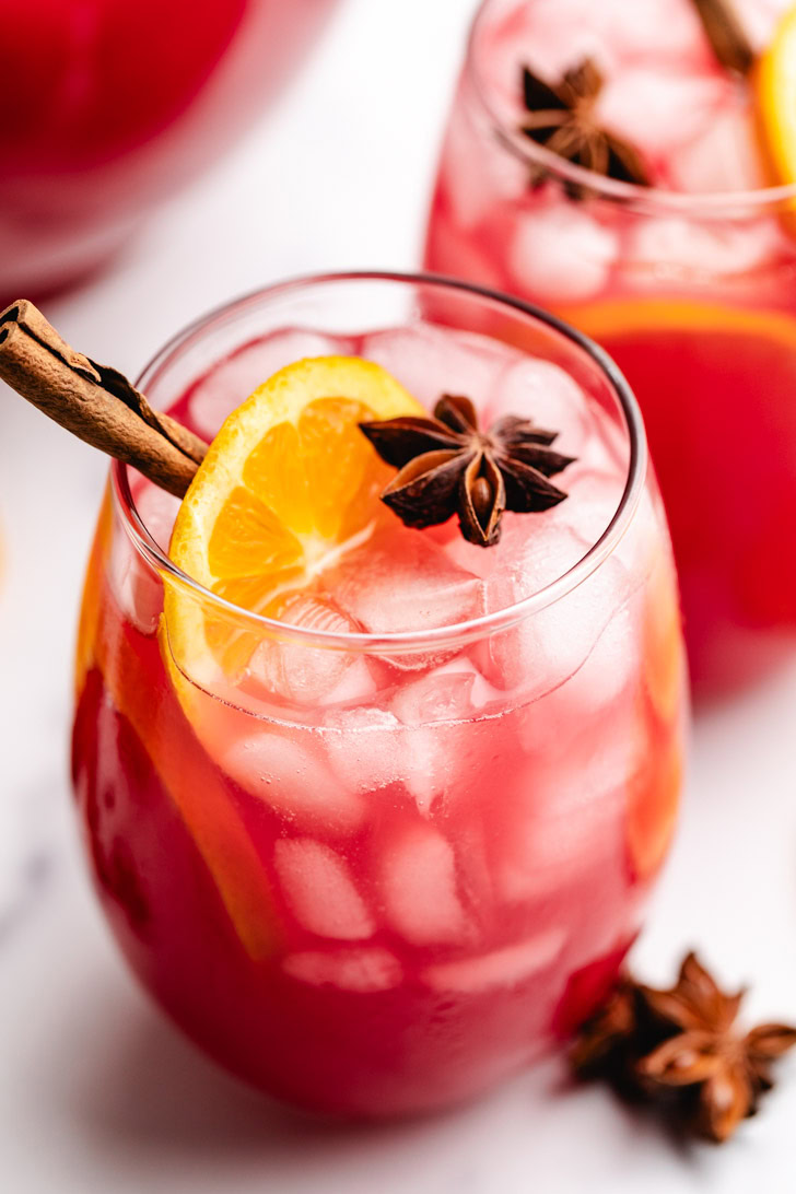 Star anise on top of a glass of cranberry punch.