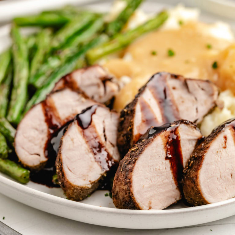 Close up view of balsamic pork tenderloin on a plate.