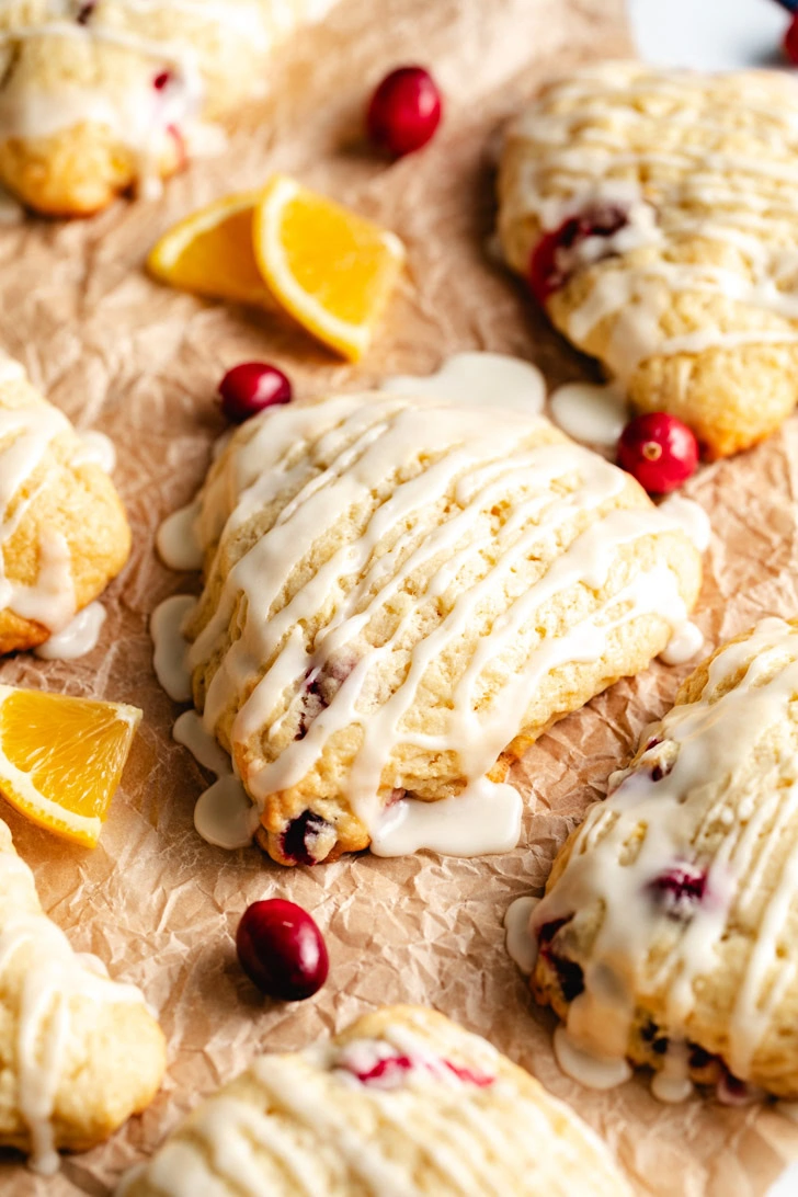 Overhead view of multiple cranberry orange scones with fresh cranberries scattered around.