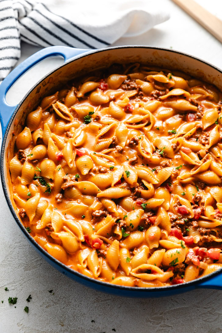 Side view of creamy pasta in a blue pan.