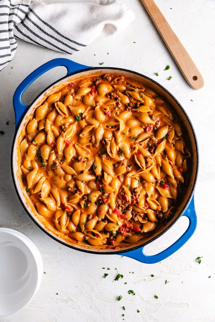 Skillet filled with cheesy pasta and ground beef.