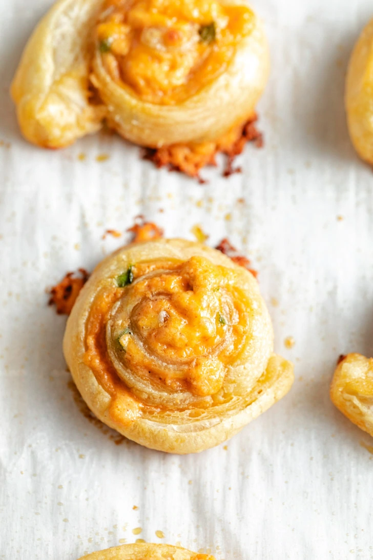 Top down view of flaky pinwheels on parchment paper.