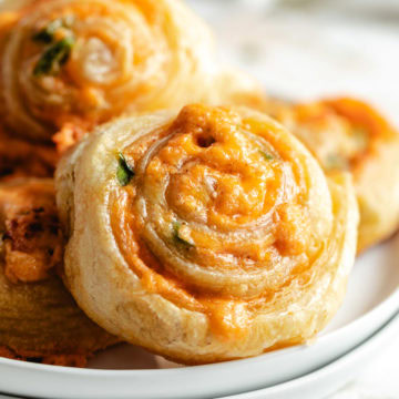 Close up view of jalapeño popper pinwheels on white plates.