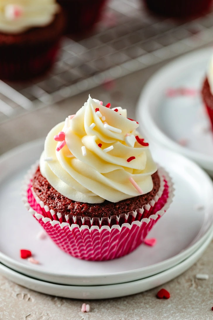 Cupcake topped with cream cheese frosting and sprinkles.