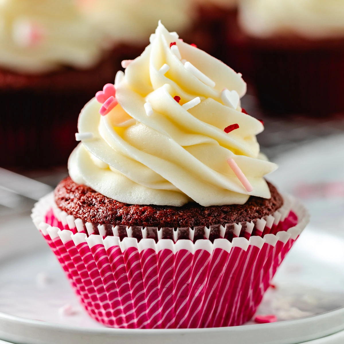 Close up view of a red velvet cupcake in a pink liner.