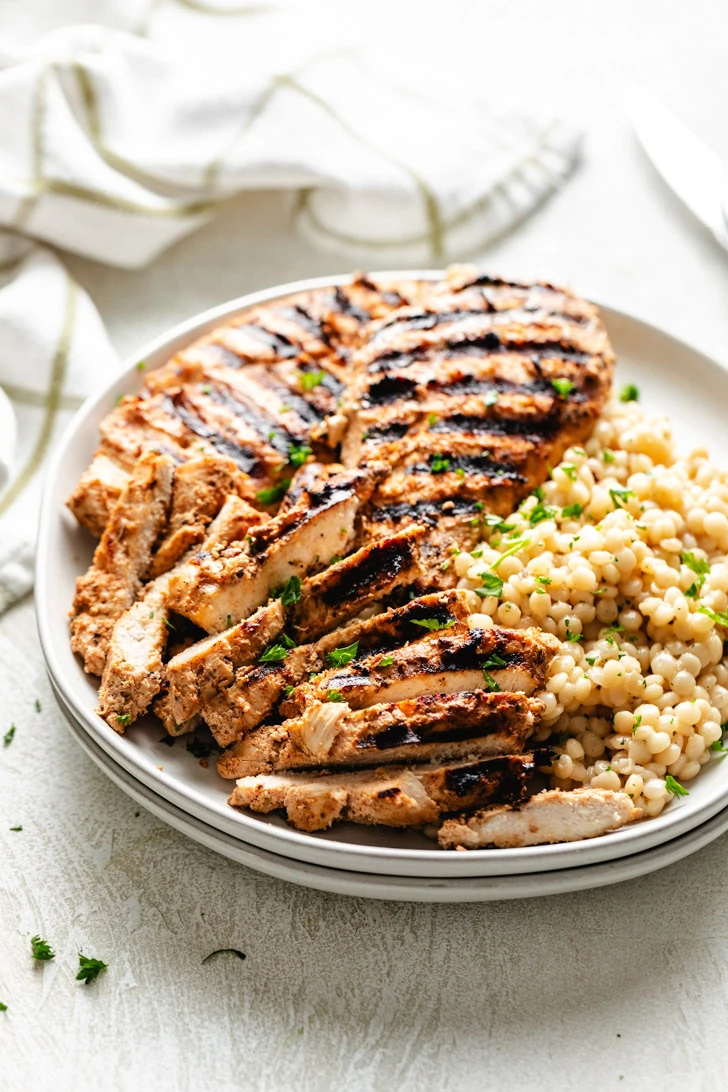 Grilled chicken on a stack of plates.