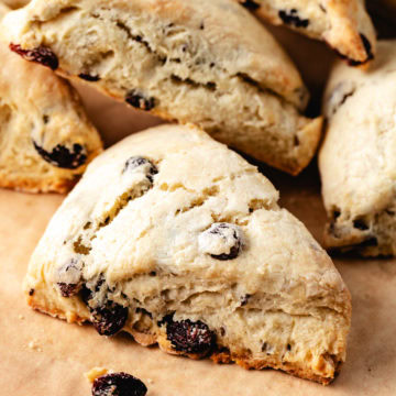 Golden irish soda bread scones with raisins on parchment paper.