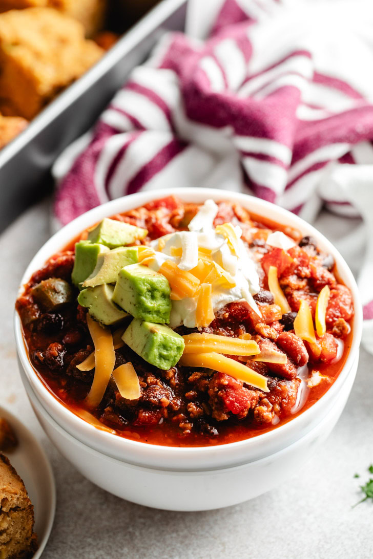 Turkey chili in a bowl with cheese and toppings.