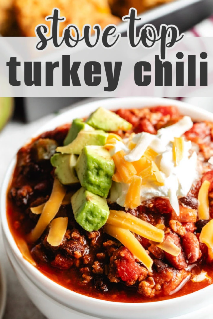 A bowl of homemade chili topped with avocado, cheese, and sour cream.