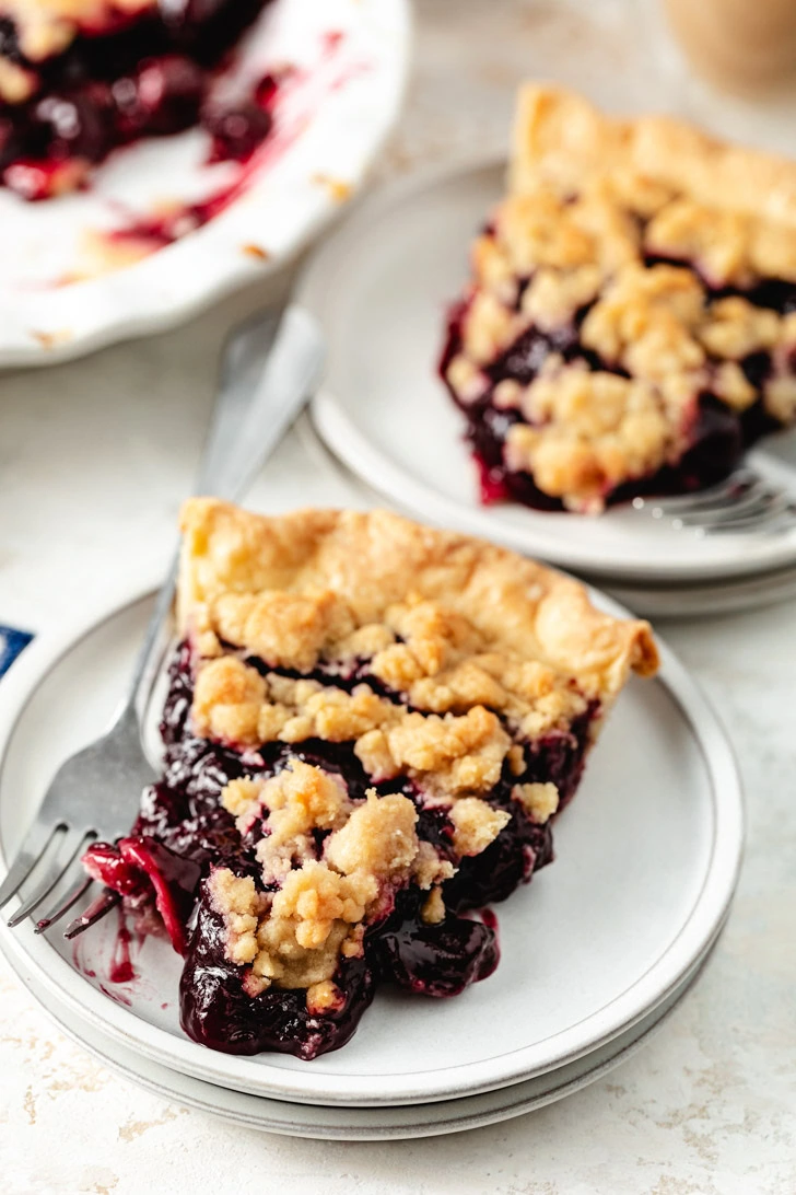 A slice of cherry pie on a plate.