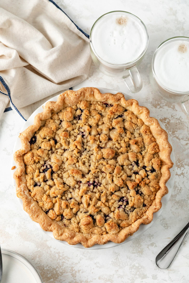 A full cherry pie with a golden brown crumble topping.