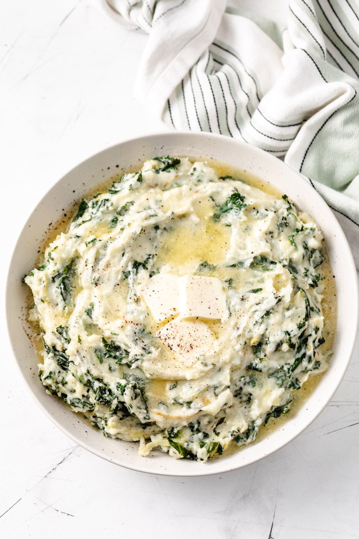 A bowl of colcannon with pats of butter melting on top.