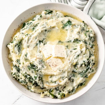 A bowl of creamy colcannon with kale and butter melting on top.