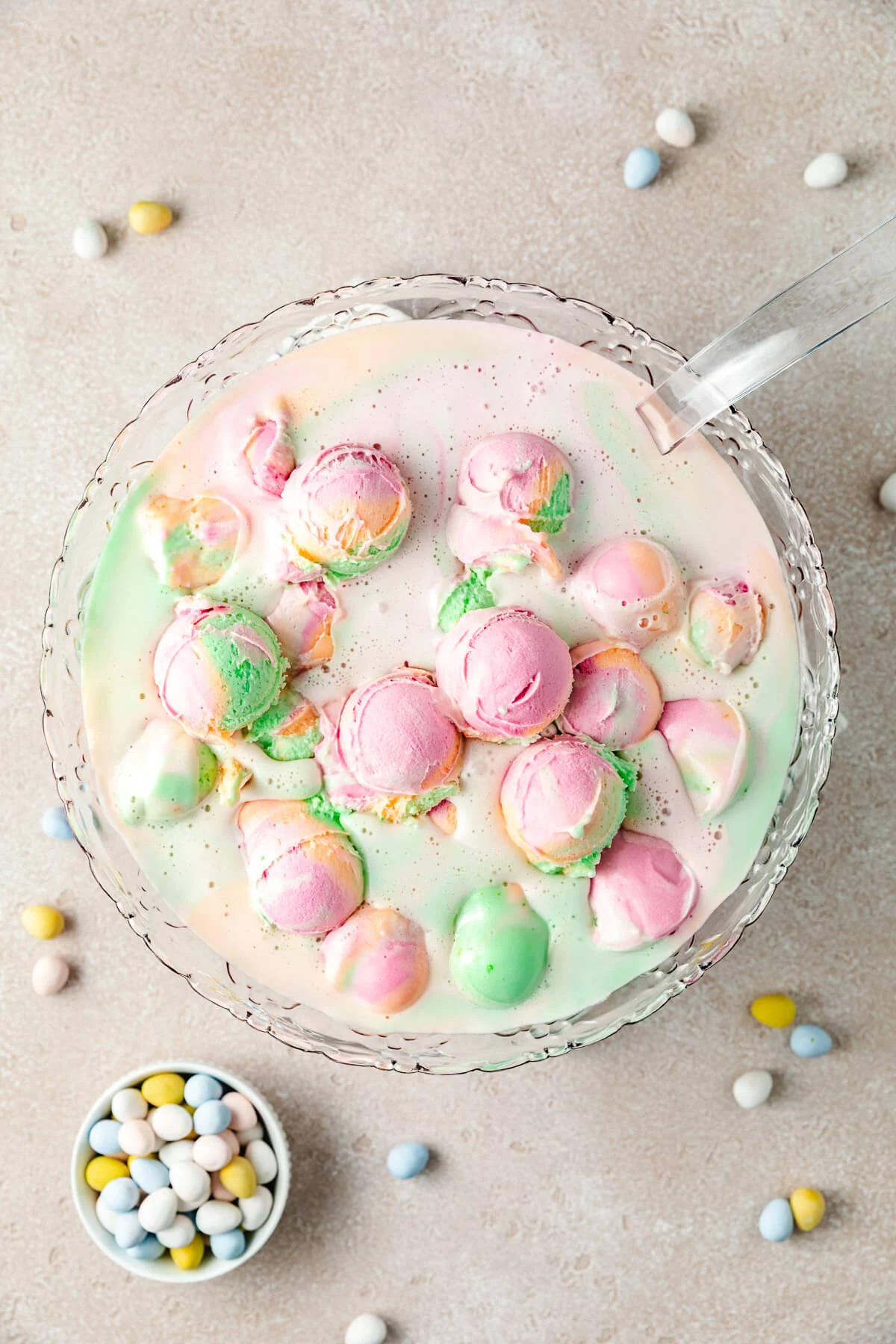 A full punch bowl of punch with pastel colors.