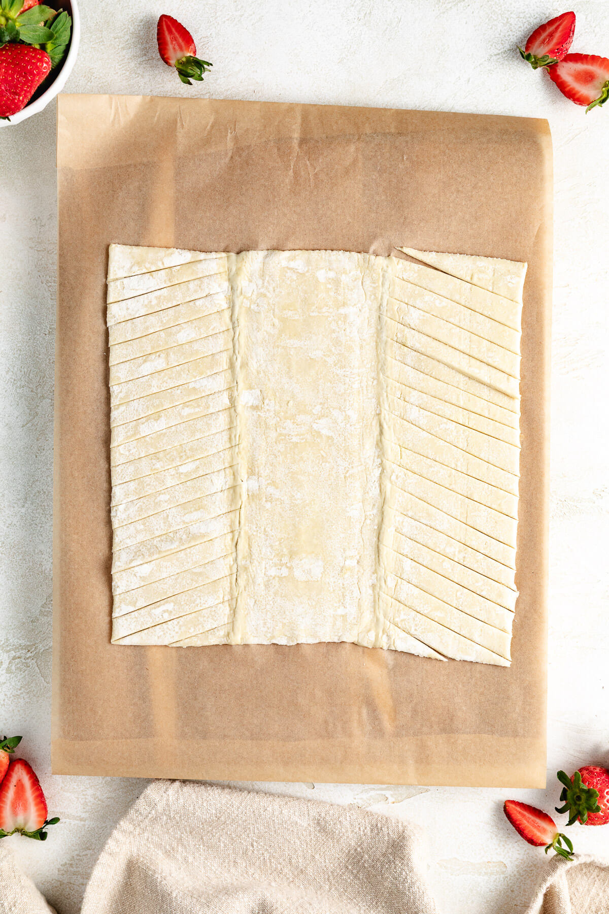 Overhead view of slits cut in puff pastry dough.