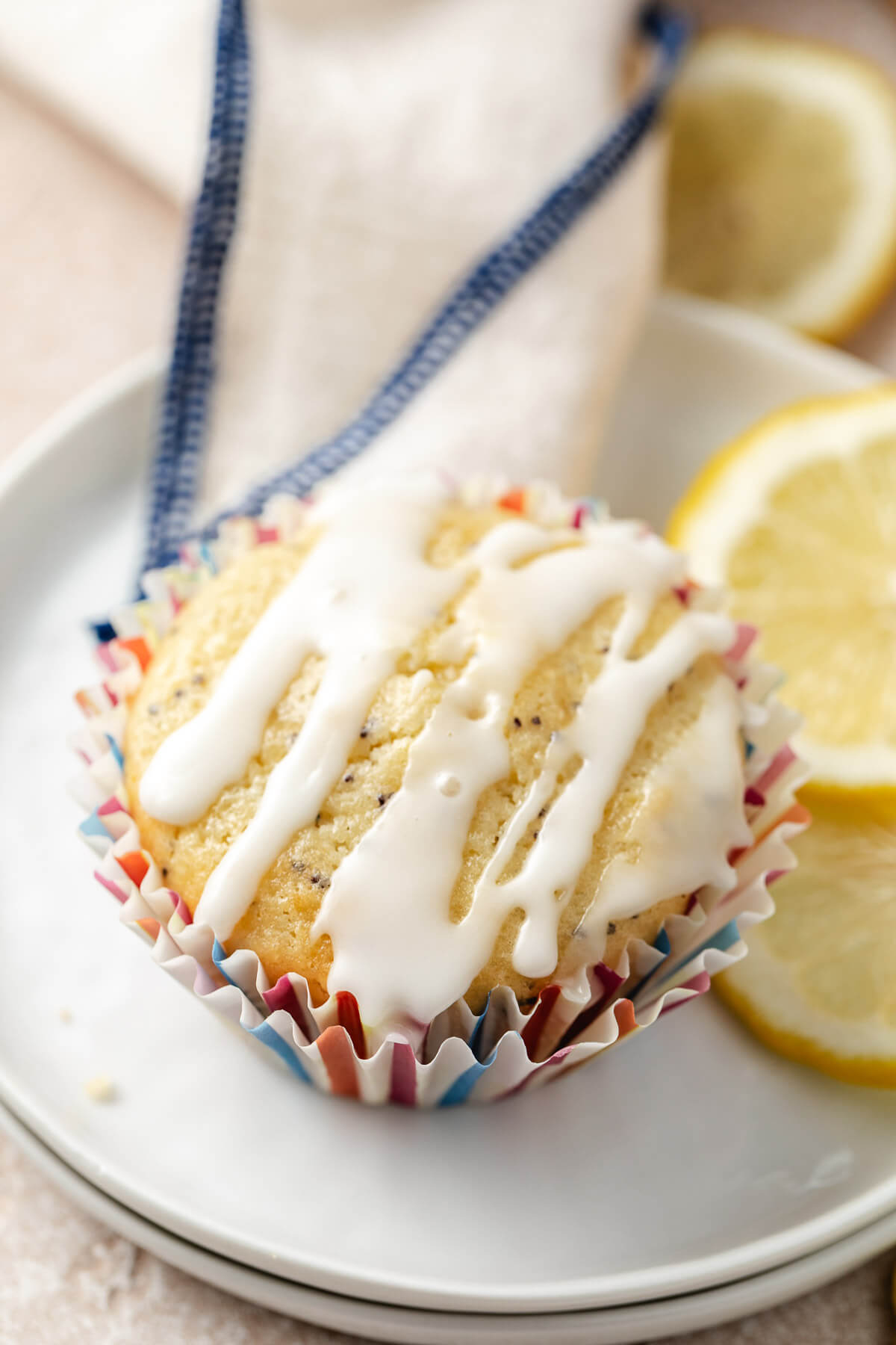White plates with a lemon poppy seed muffin on top.