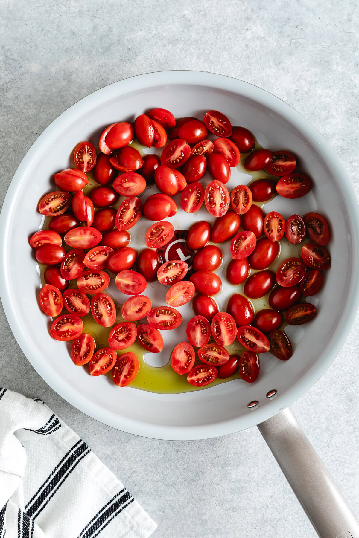 Cherry tomatoes and olive oil in a pan.