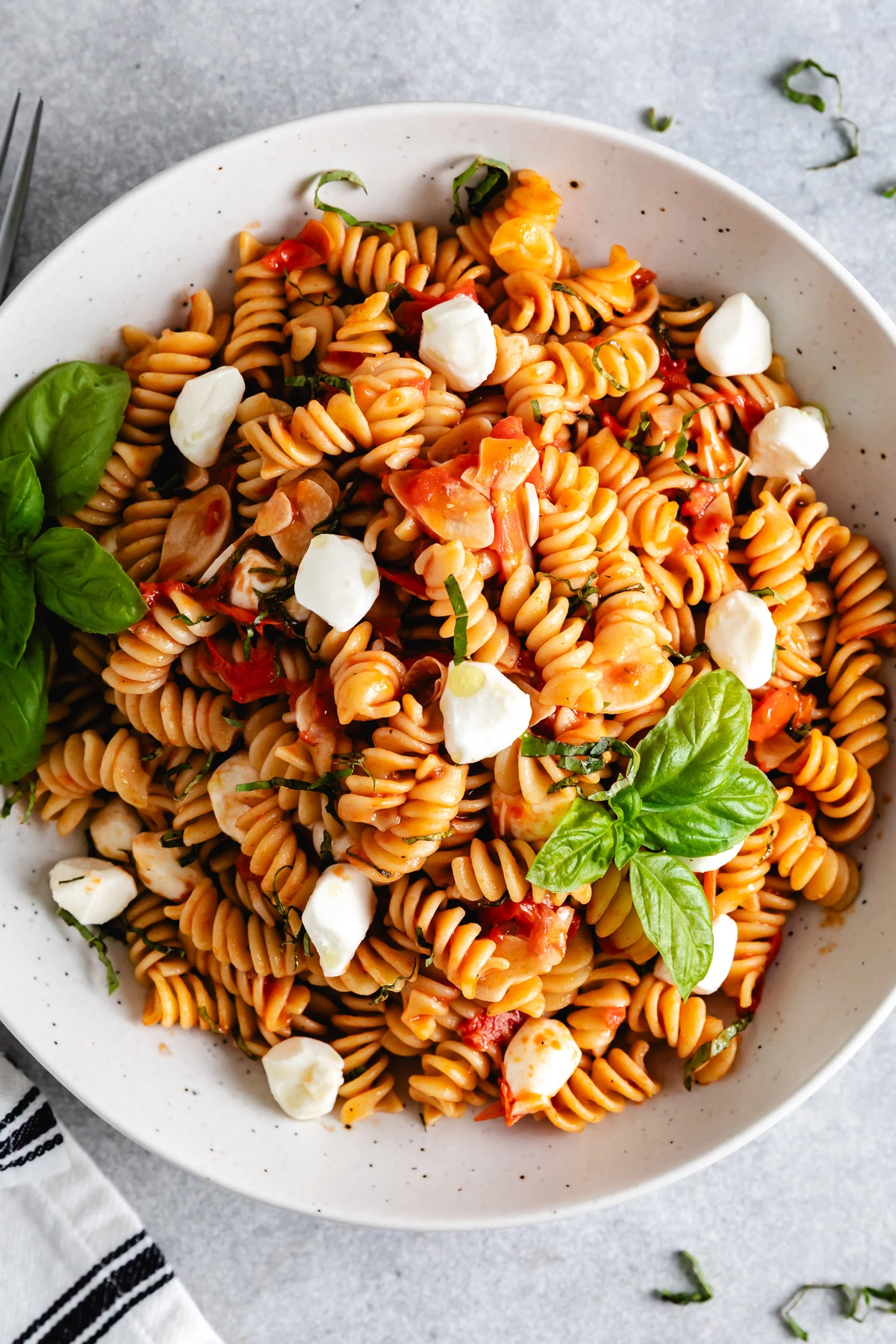 Overhead view of pasta with mozzarella pearls.