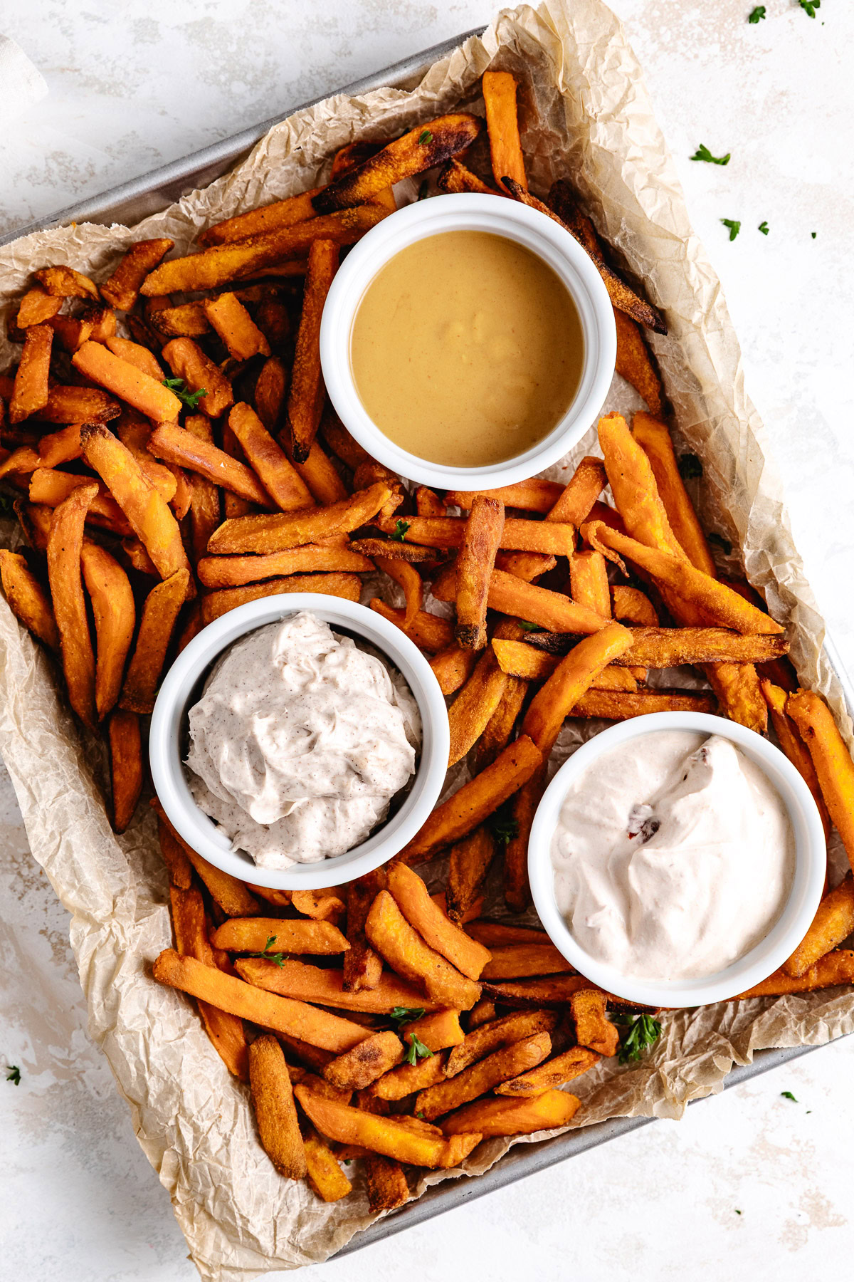 Overhead view of fries and dipping sauces on a tray.