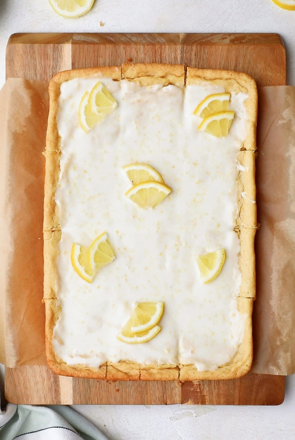 Iced lemon cookies on a cutting board.