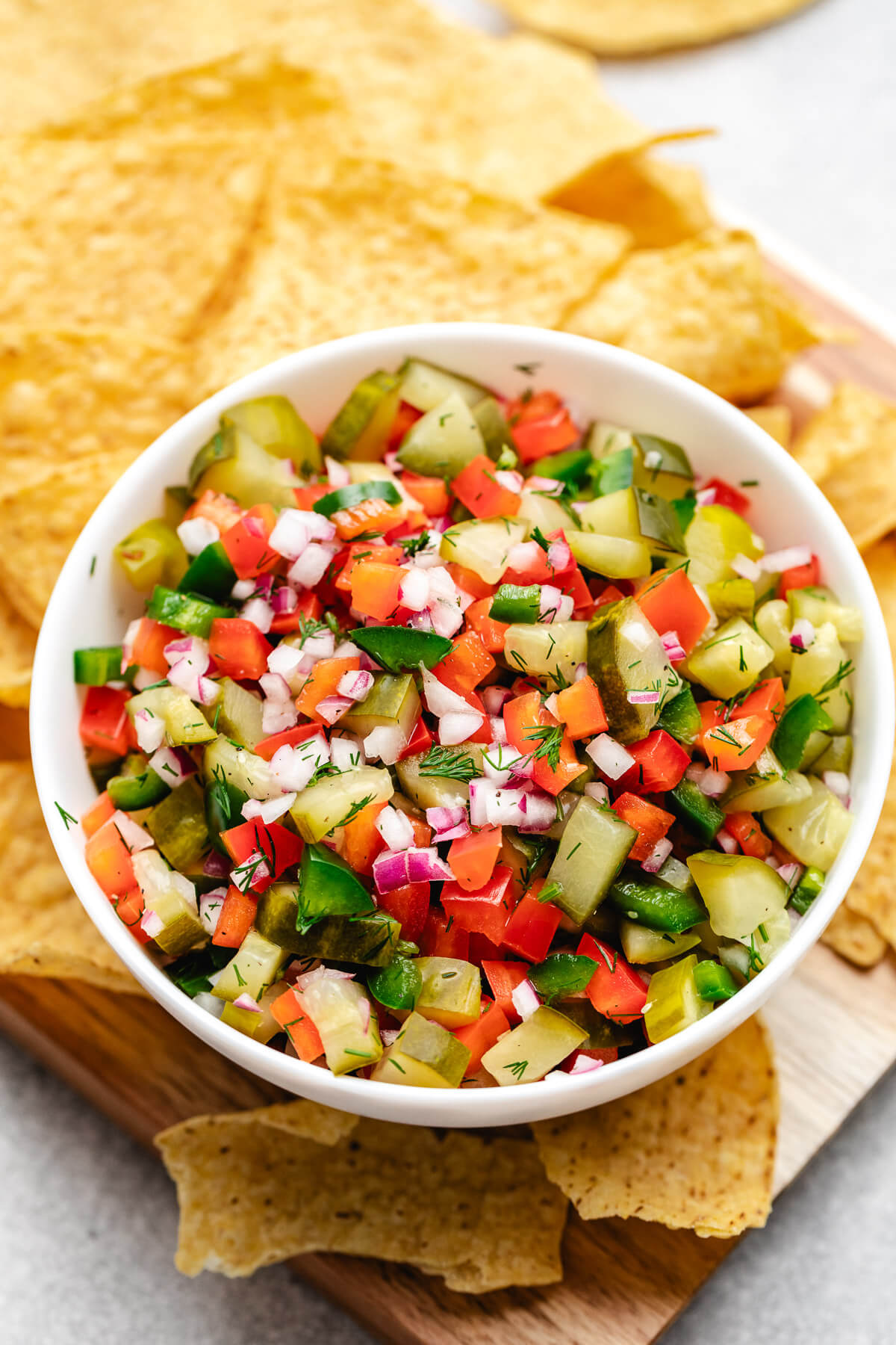 Pickle De Gallo Overhead view of chips and salsa on a wooden board.