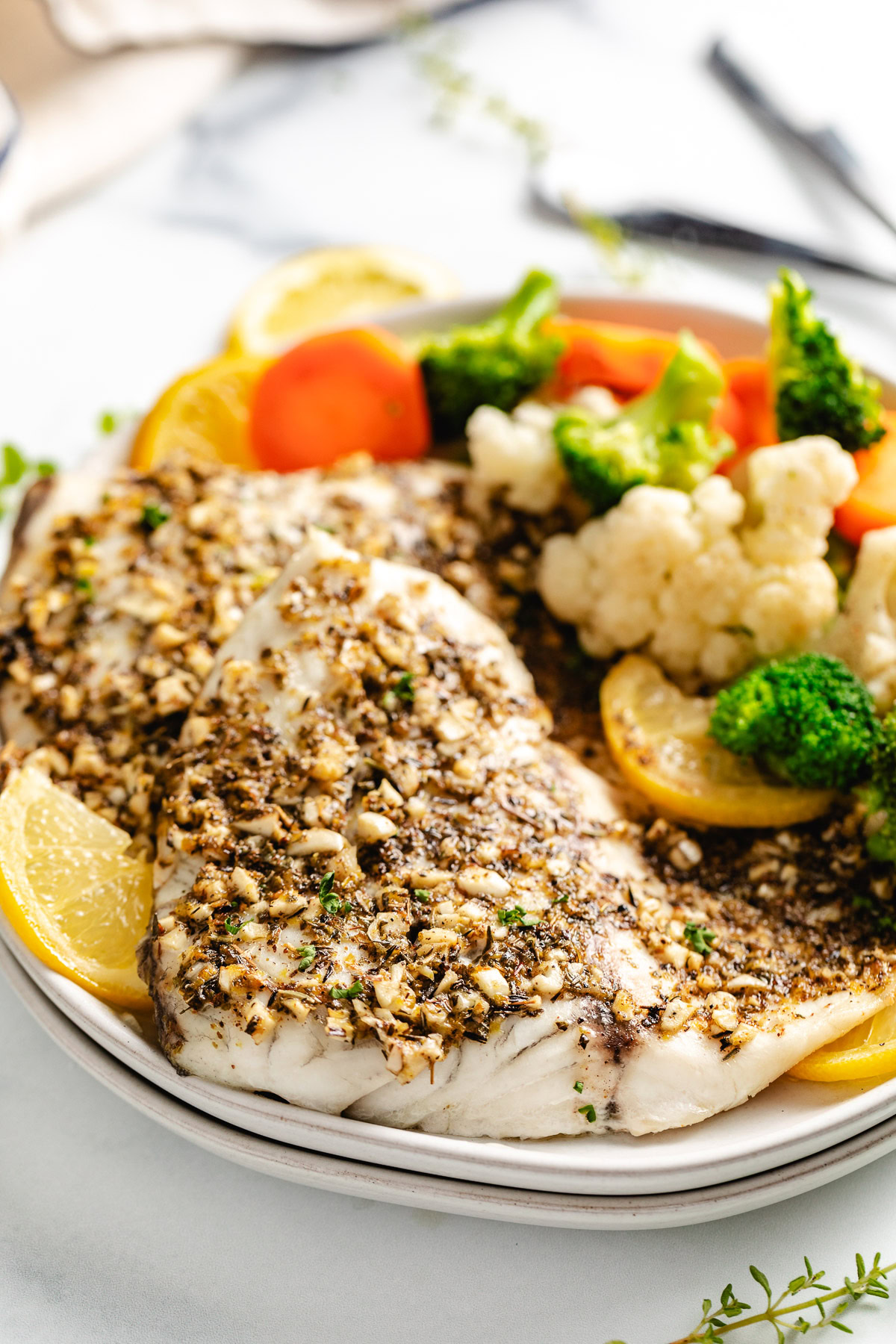 Lemon Garlic Barramundi Baked barramundi on a plate.
