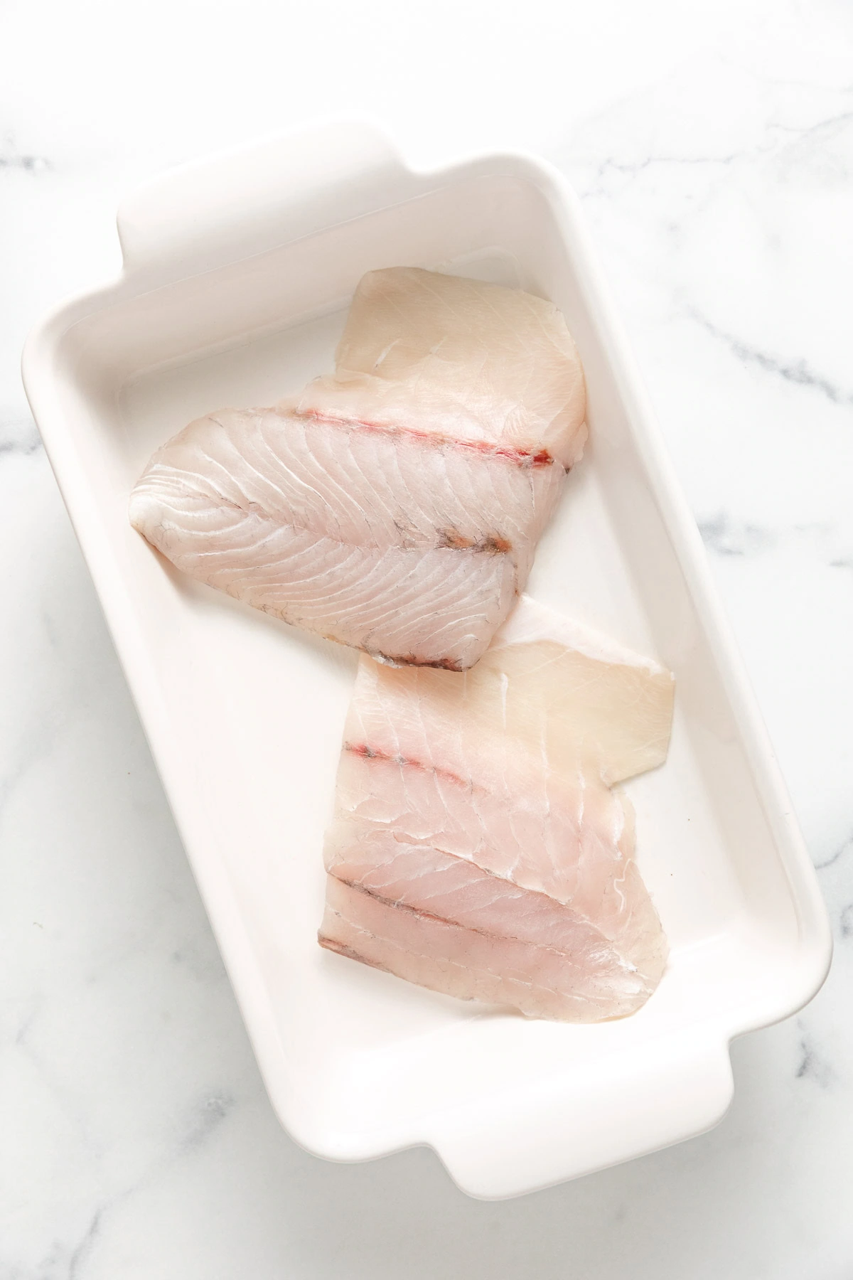 Fish filets in a baking dish.