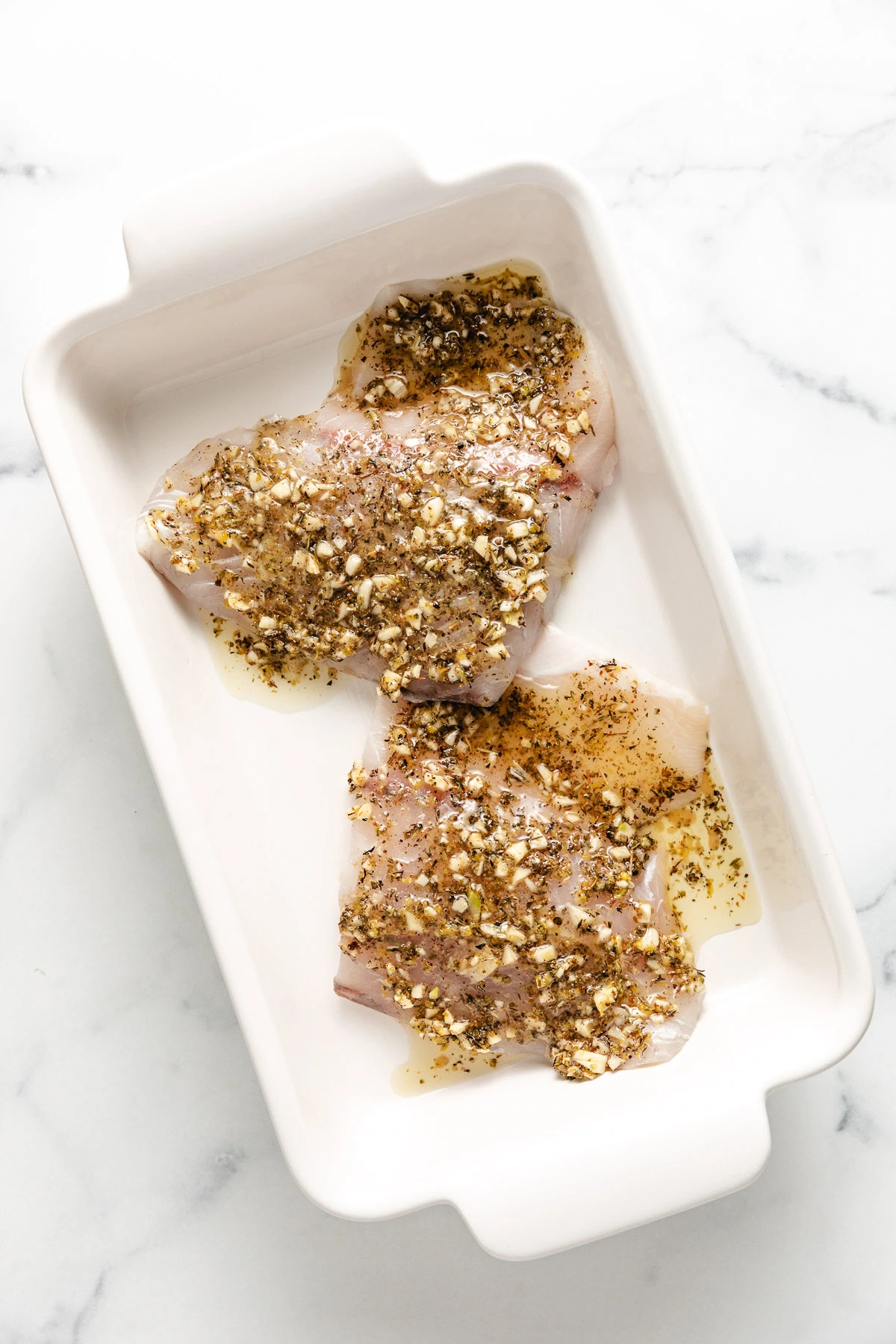 White fish with garlic lemon butter spooned over the top.