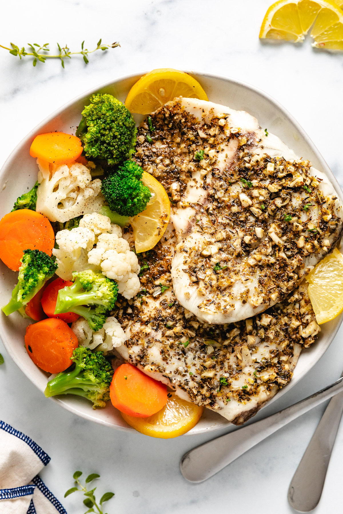 Overhead view of fish and veggies on a plate.