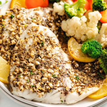Close up view of barramundi on a stack of plates.