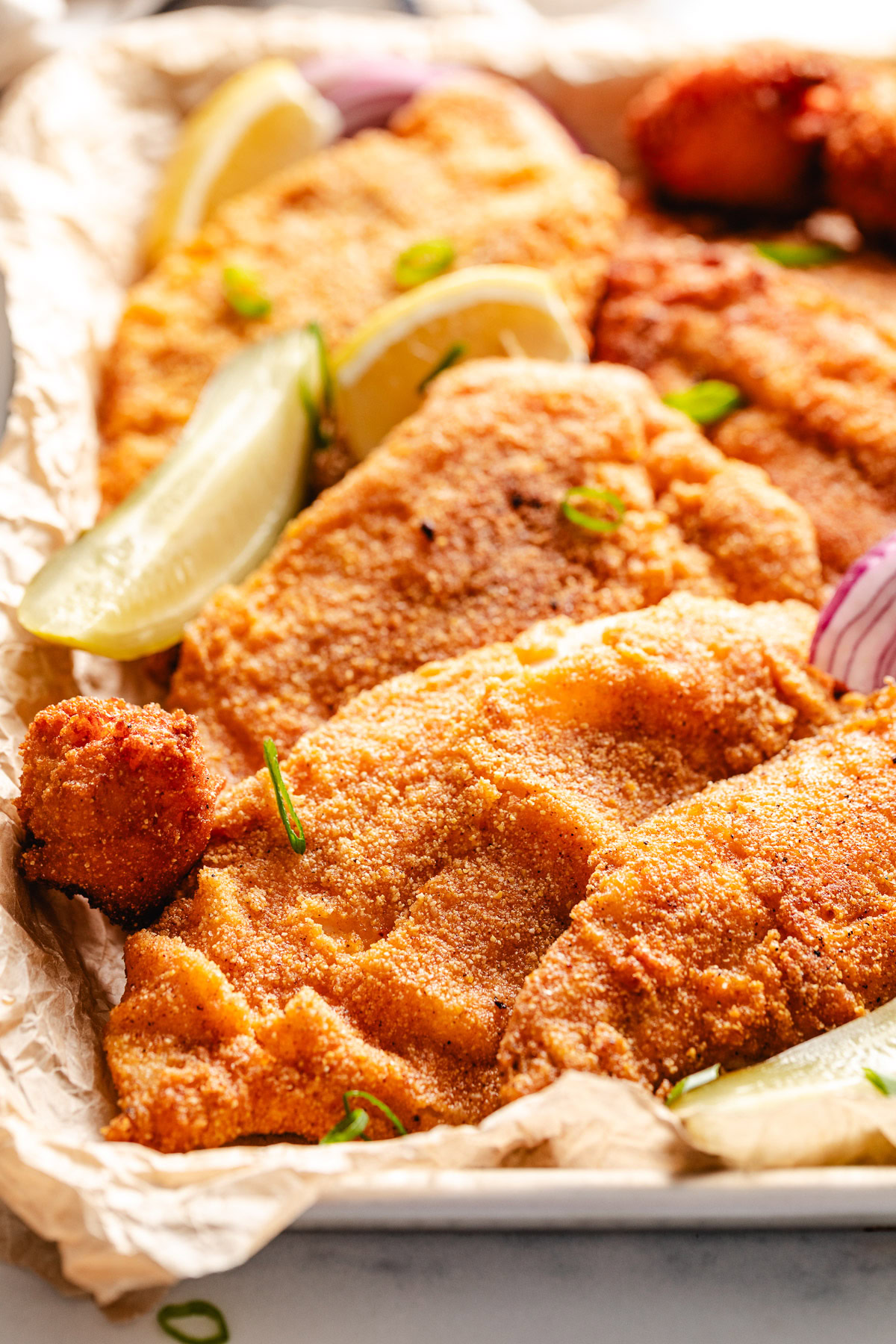 Fried Catfish Lemons and pickles next to pickles and lemon.