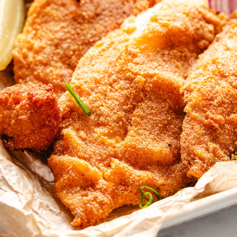 Fried catfish on a pan with lemon.