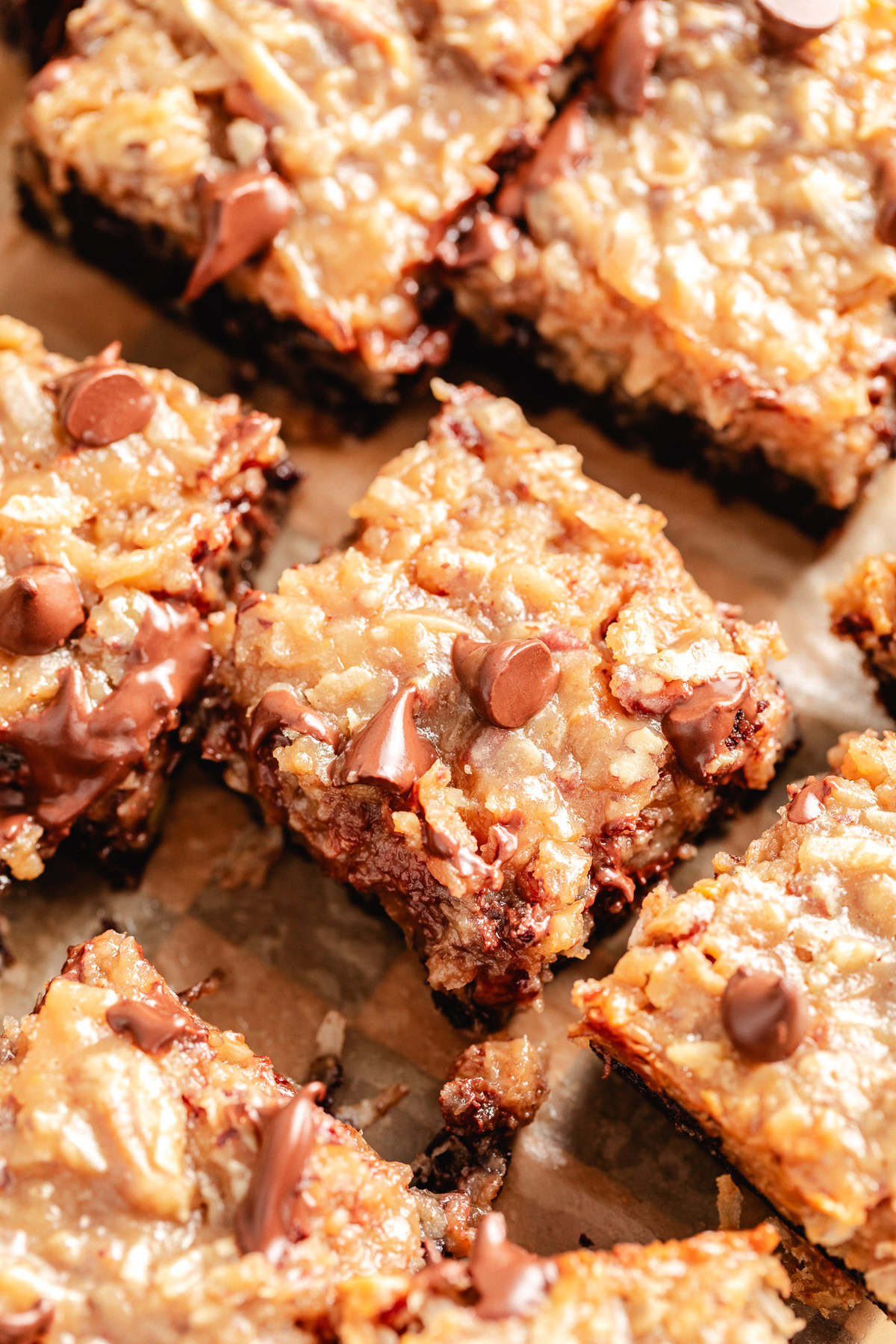 German Chocolate Brownies Brownies with coconut pecan topping on parchment.