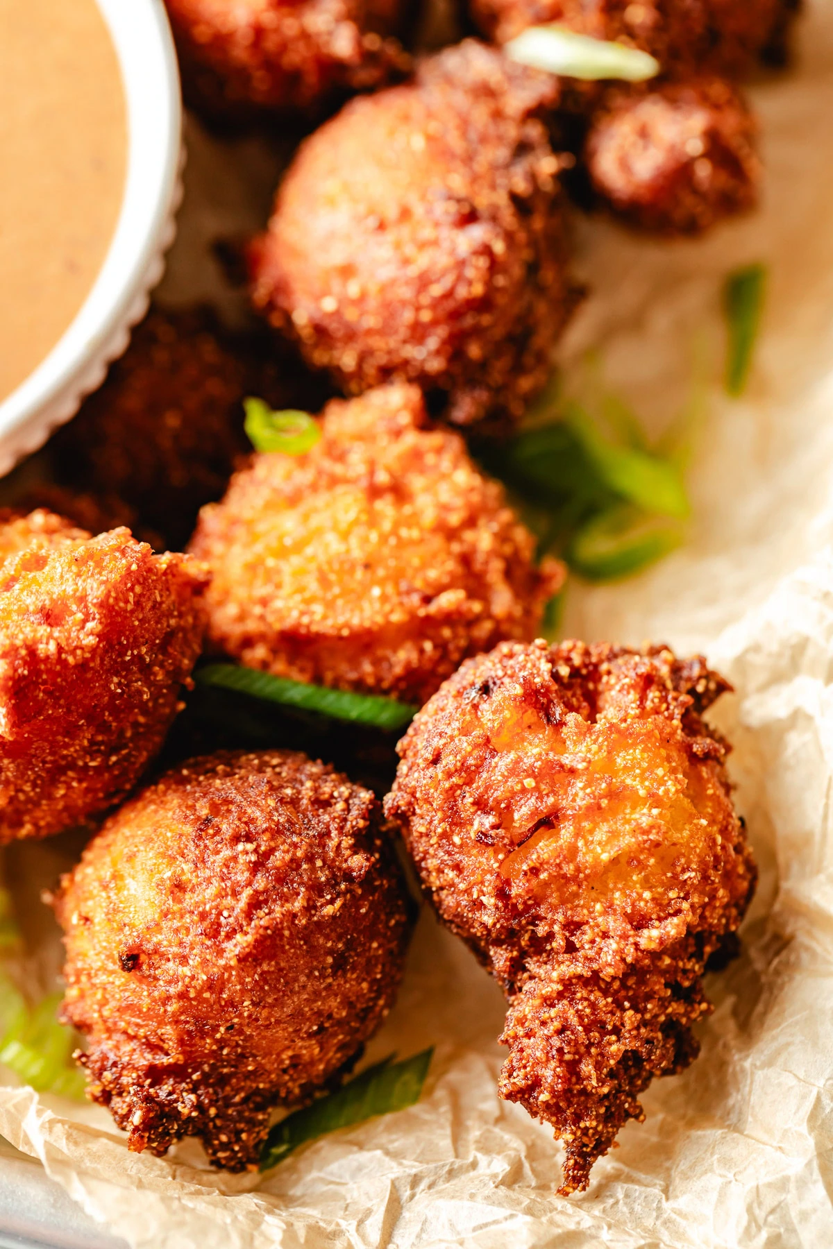 Fried hush puppies on parchment.