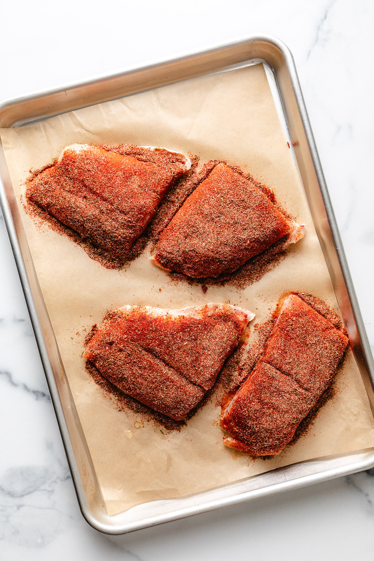 Seasoned fish on a pan.