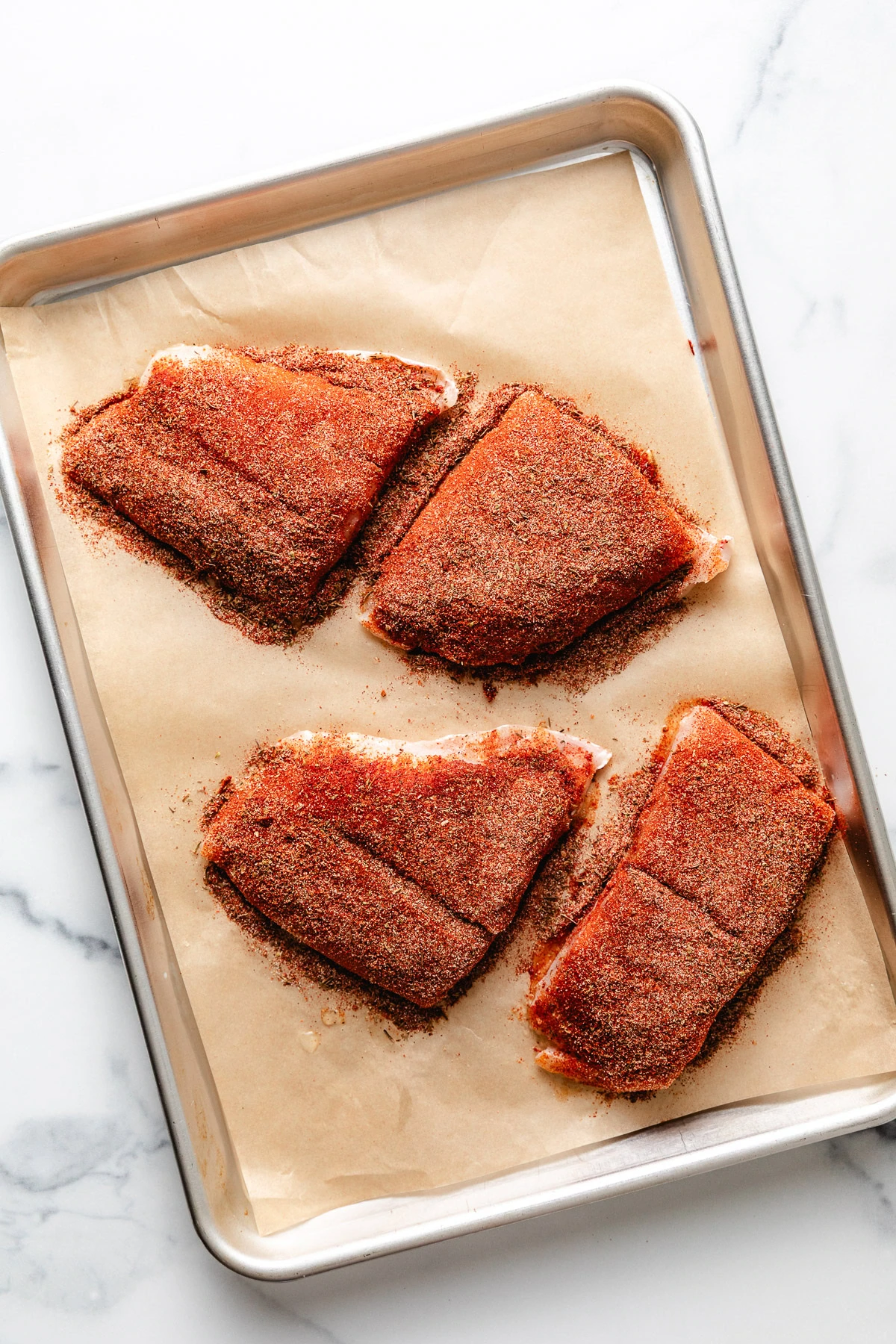 Seasoned fish on a pan.