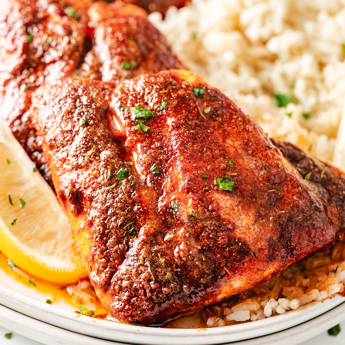 Blackened red snapper next to lemon.