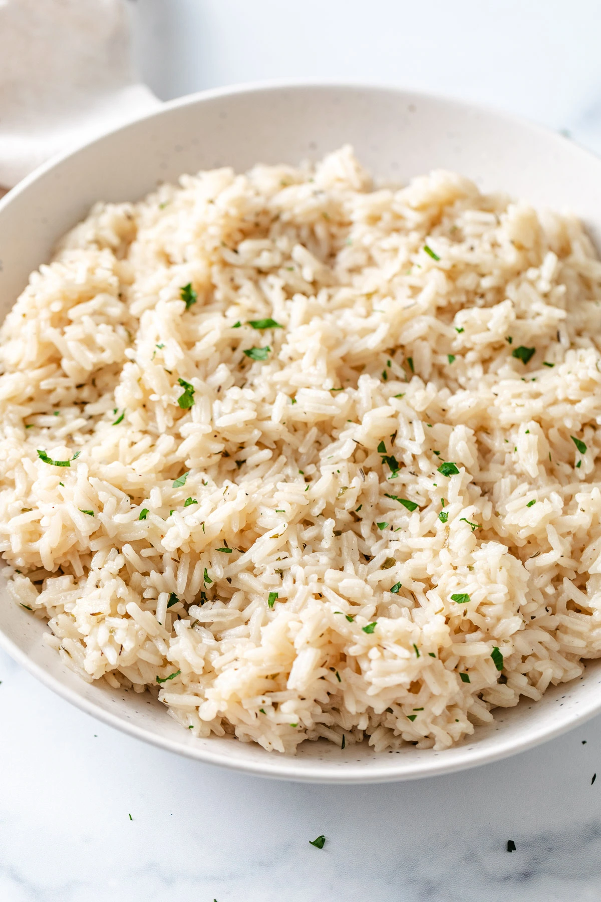 Herb rice in a speckled dish.