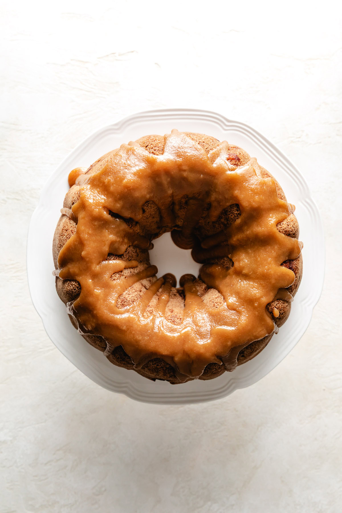 Overhead view of brown sugar sauce added to an apple cake.