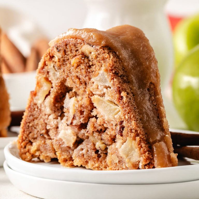 Close up view of a slice of apple bundt cake on a plate.