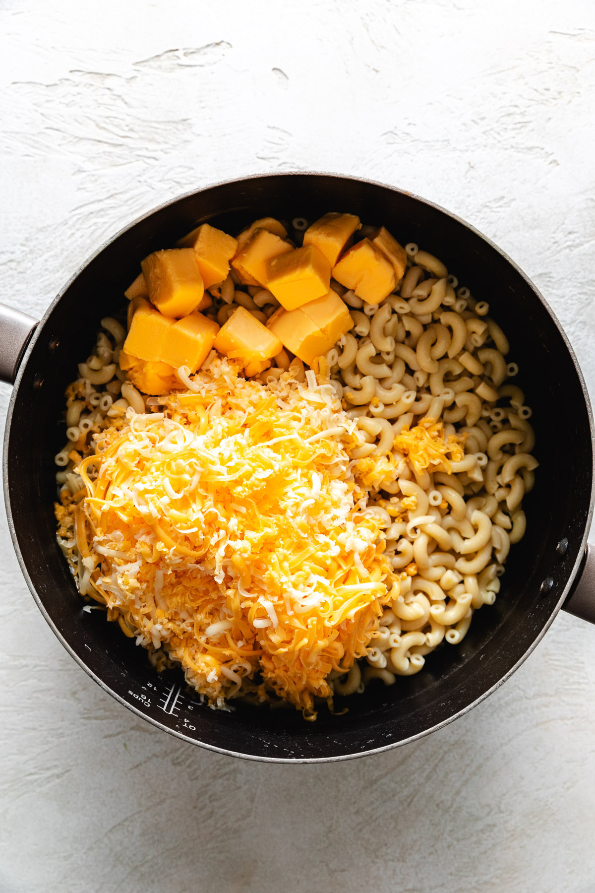 Elbow noodles, cheese, and butter in a pan.