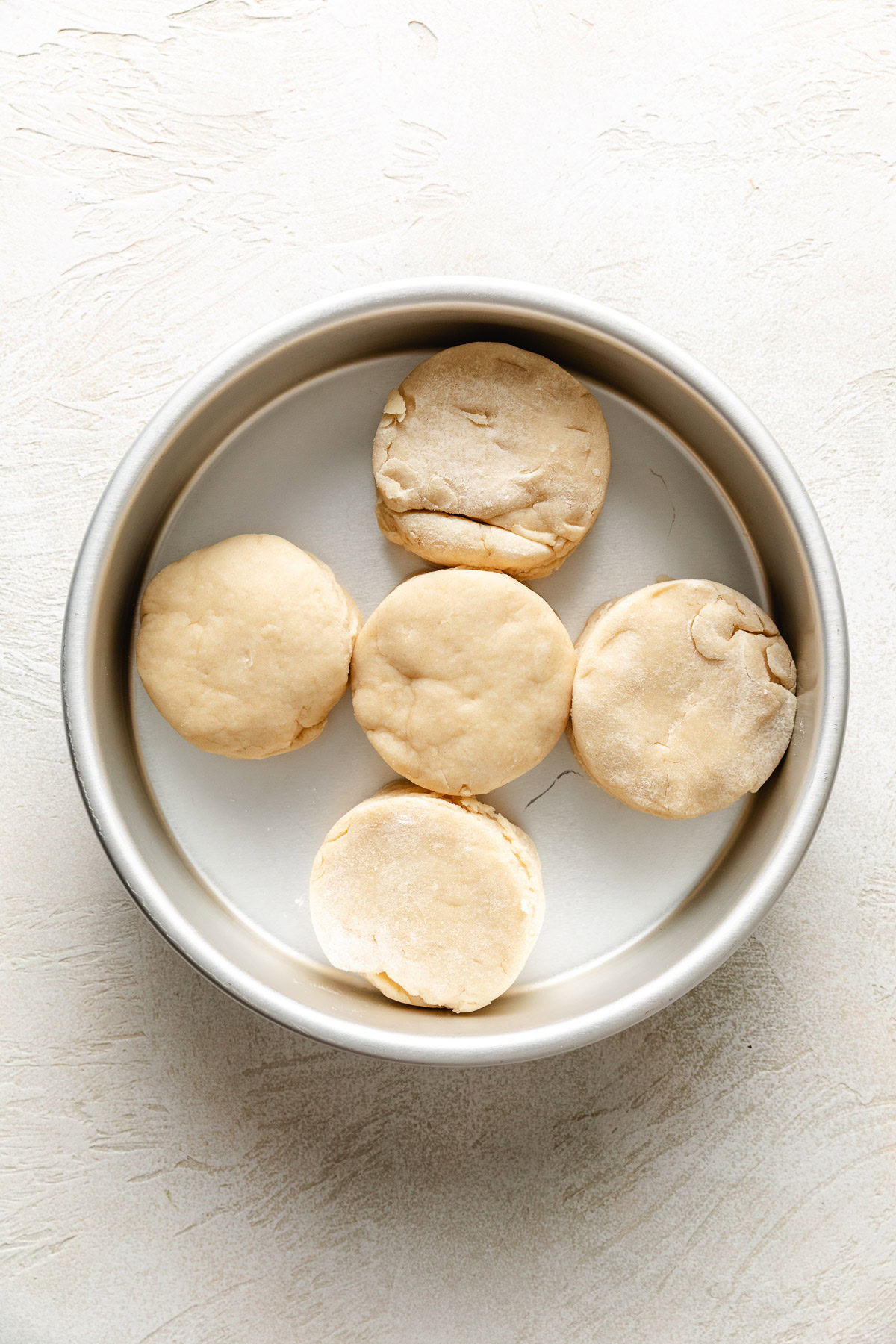 Unbaked biscuit dough in a pan.
