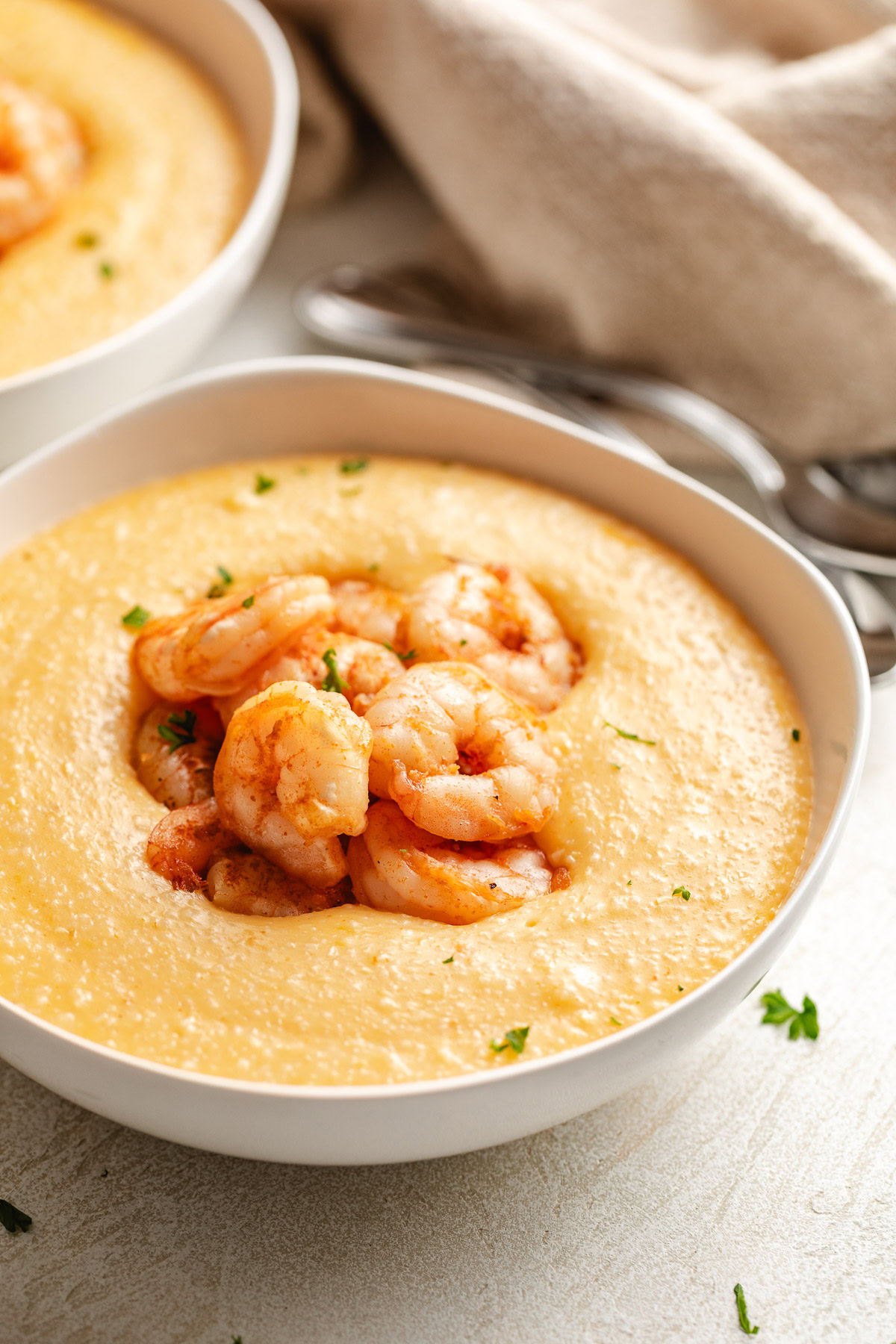 White bowl filled with cajun shrimp and grits.