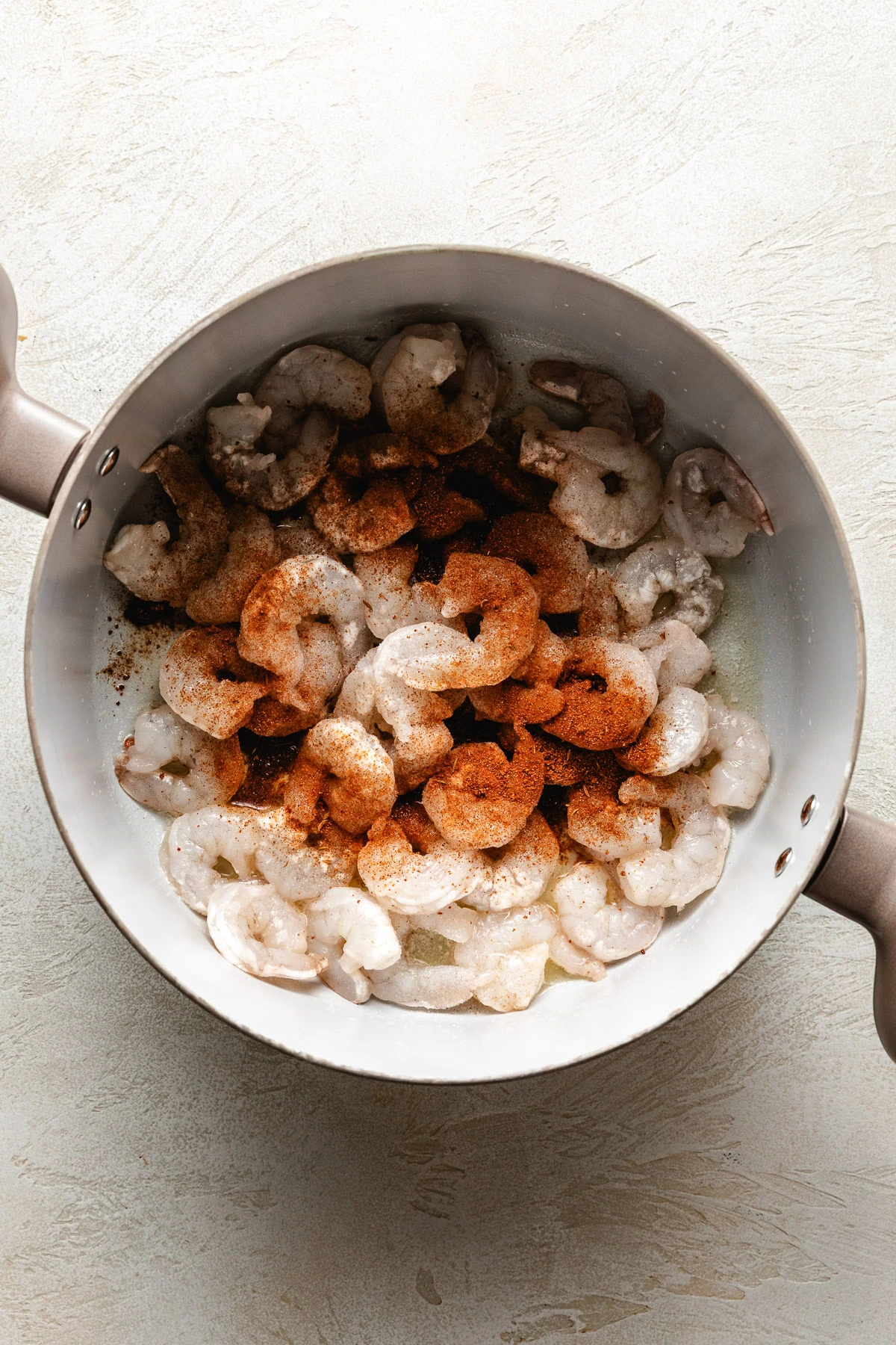 Shrimp and seasoning in a pan.