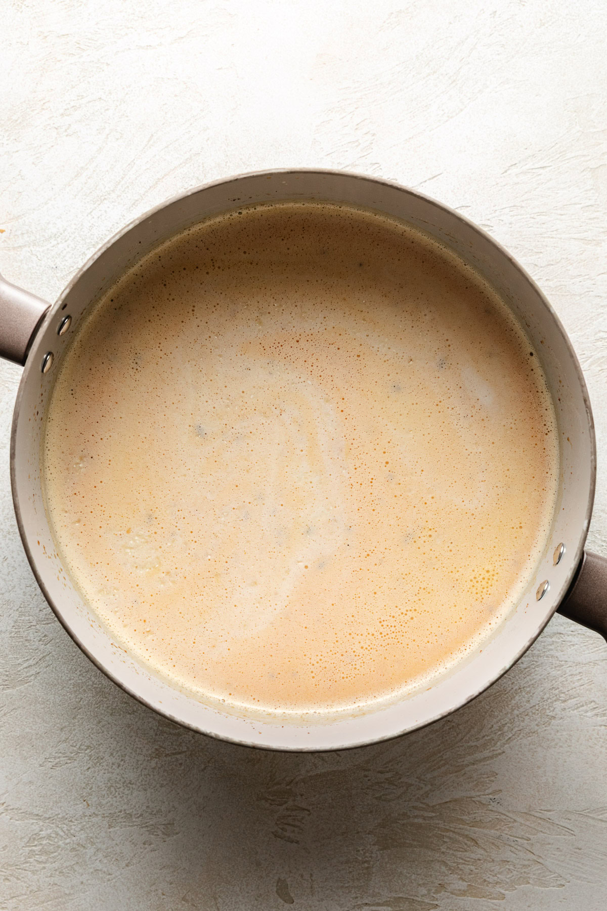 Grits, water, and milk in a pan.