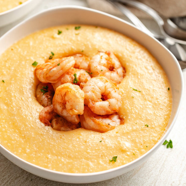 Close up view of cheesy cajun shrimp and grits.