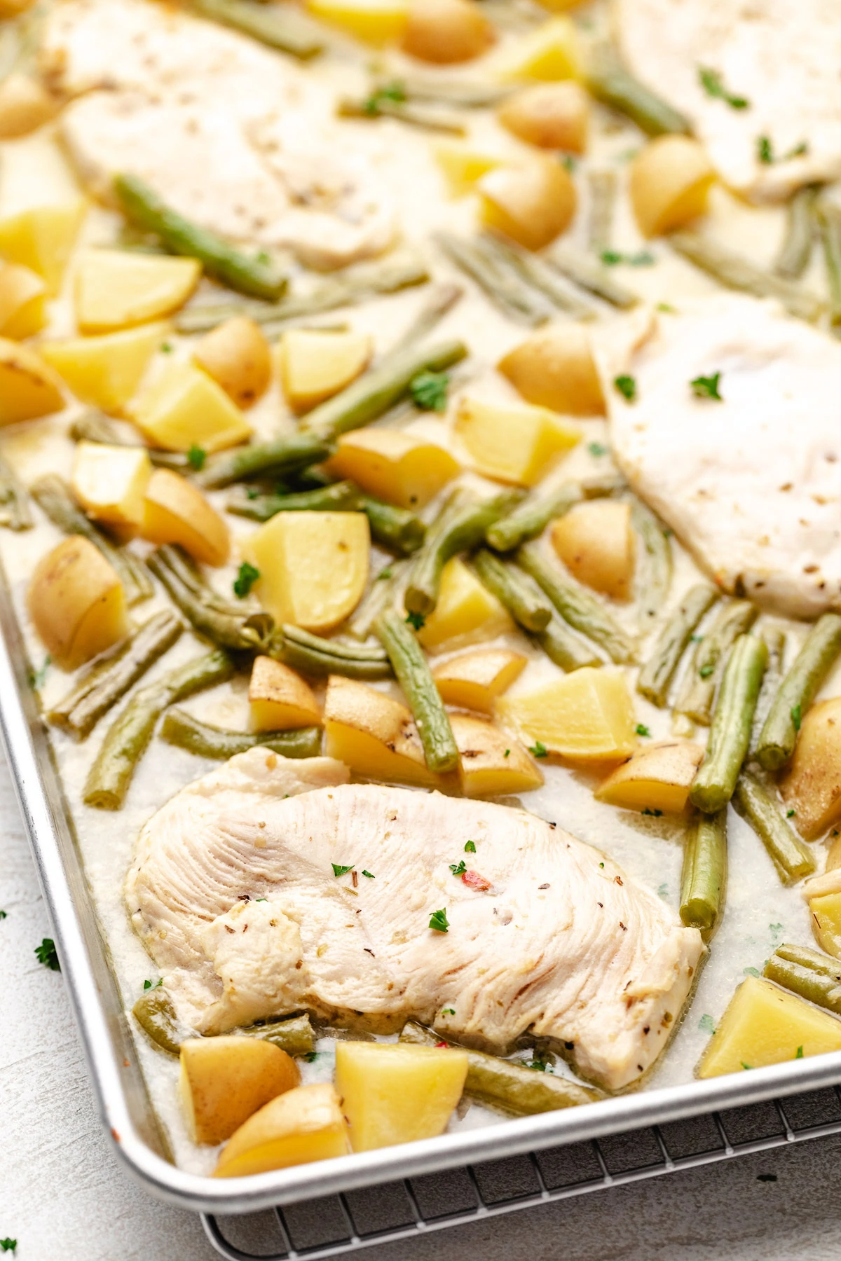 Sheet pan filled with chicken green beans and potatoes.