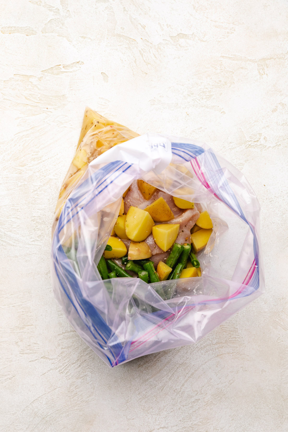 Open bag filled with chicken and vegetables.
