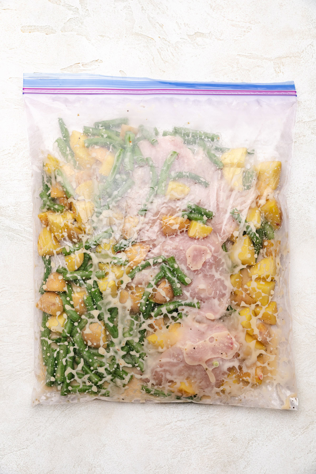 Chicken, veggies, and italian dressing in a ziploc bag.
